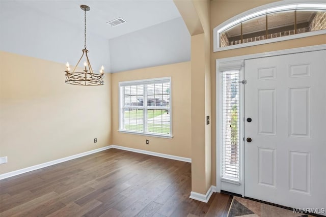 entryway featuring a chandelier, baseboards, dark wood-type flooring, and high vaulted ceiling