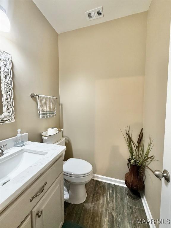 828 Warrior Dr, Valley Grande, AL 36701 - half bath featuring toilet, wood finished floors, vanity, and baseboards