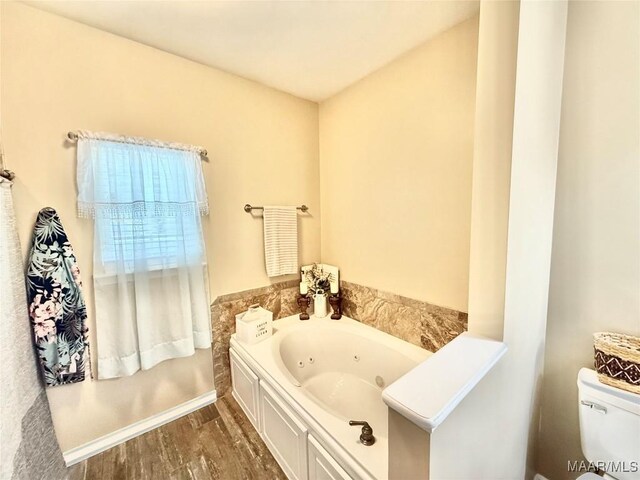 828 Warrior Dr, Valley Grande, AL 36701 - bathroom with a tub with jets, toilet, and baseboards