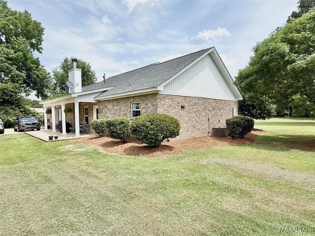 828 Warrior Dr, Valley Grande, AL 36701 - rear view of property with brick siding, a yard, a chimney, and central AC unit
