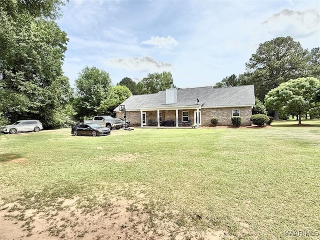 828 Warrior Dr, Valley Grande, AL 36701 - back of house featuring a lawn, a porch, brick siding, and a chimney
