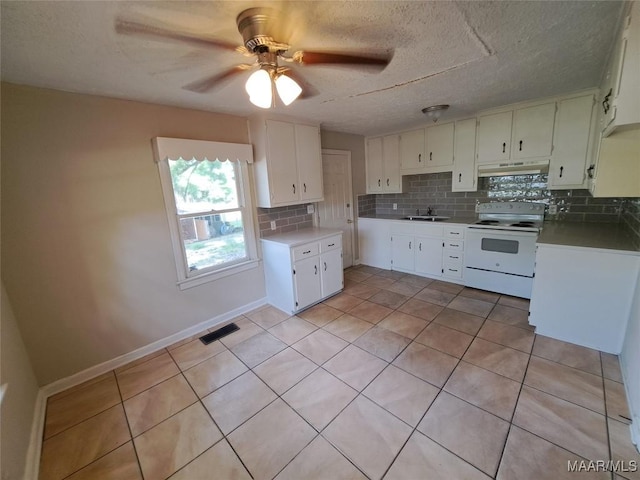 1960 Yarbrough St, Montgomery, AL 36110 - kitchen with white electric range oven, under cabinet range hood, a sink, backsplash, and light tile patterned flooring