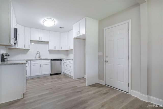 3468 Biltmore Ave, Montgomery, AL 36109 - kitchen featuring stainless steel appliances, a sink, light wood-style flooring, backsplash, and white cabinets