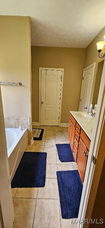 6200 Sycamore Dr, Montgomery, AL 36117 - full bath featuring vanity, a bath, tile patterned floors, a textured ceiling, and a chandelier