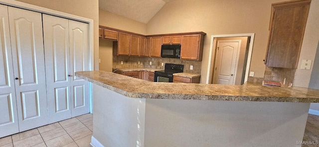 6200 Sycamore Dr, Montgomery, AL 36117 - kitchen with black microwave, stove, a peninsula, lofted ceiling, and tasteful backsplash