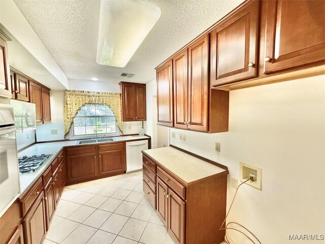 441 County Road 401, Selma, AL 36701 - kitchen featuring a sink, white appliances, a textured ceiling, brown cabinetry, and light tile patterned flooring