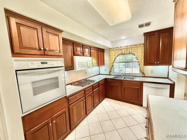 441 County Road 401, Selma, AL 36701 - kitchen with white appliances, a sink, a textured ceiling, and brown cabinets