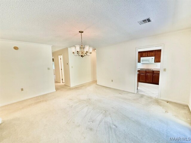 441 County Road 401, Selma, AL 36701 - spare room with a chandelier, light carpet, a textured ceiling, and baseboards