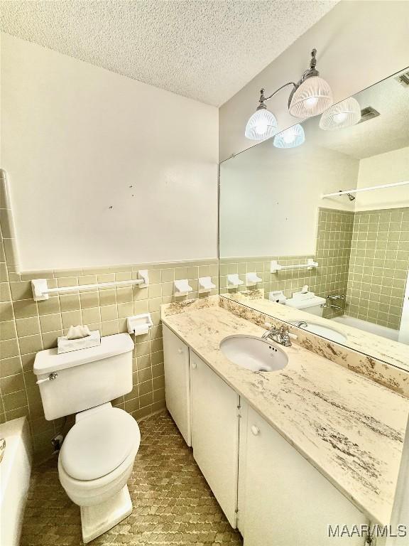 441 County Road 401, Selma, AL 36701 - bathroom featuring toilet, tile walls, a textured ceiling, vanity, and wainscoting