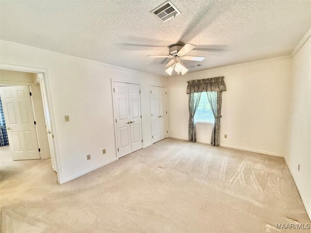 441 County Road 401, Selma, AL 36701 - unfurnished bedroom with multiple closets, light carpet, crown molding, a textured ceiling, and baseboards