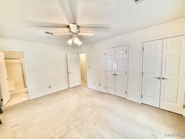 441 County Road 401, Selma, AL 36701 - unfurnished bedroom featuring multiple closets, light carpet, a textured ceiling, baseboards, and ensuite bathroom