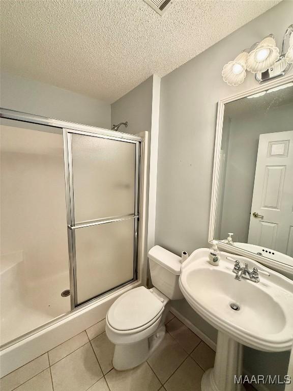 441 County Road 401, Selma, AL 36701 - bathroom with a textured ceiling, a shower stall, tile patterned flooring, and toilet