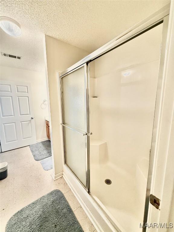 441 County Road 401, Selma, AL 36701 - full bathroom featuring a textured ceiling, a shower stall, baseboards, and tile patterned floors