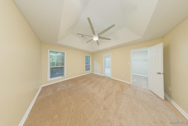929 Ironwood Dr, Montgomery, AL 36117 - unfurnished bedroom featuring a raised ceiling, light carpet, a walk in closet, baseboards, and ceiling fan
