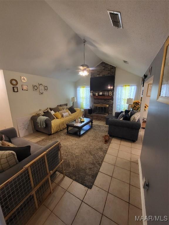 480 Avon Rd, Montgomery, AL 36109 - living area featuring light tile patterned floors, a ceiling fan, plenty of natural light, lofted ceiling, and a brick fireplace
