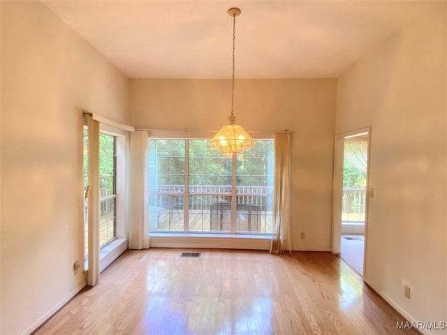 4564 Hickory Grove Rd W, Letohatchee, AL 36047 - unfurnished dining area featuring wood finished floors, a chandelier, and baseboards
