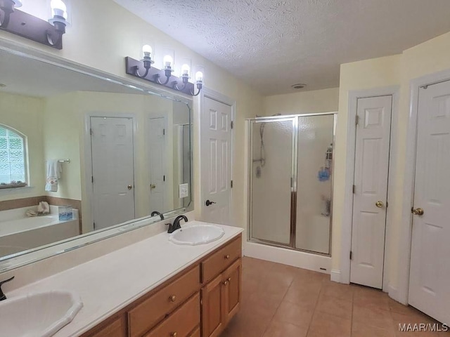 40 Larkspur Ln, Millbrook, AL 36054 - bathroom with a shower stall, tile patterned flooring, double vanity, a textured ceiling, and a garden tub