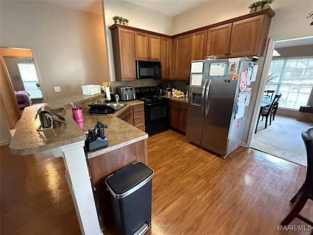 3701 Claiborne Cir, Montgomery, AL 36116 - kitchen with black appliances, a peninsula, a sink, and plenty of natural light