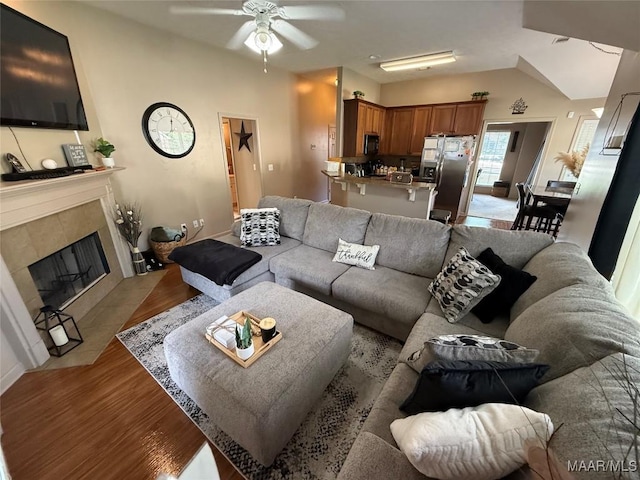 3701 Claiborne Cir, Montgomery, AL 36116 - living area with a ceiling fan, light wood finished floors, a tile fireplace, lofted ceiling, and baseboards