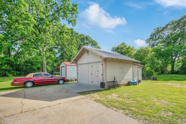 258 S Conecuh St, Greenville, AL 36037 - detached garage featuring a storage shed and view of wooded area