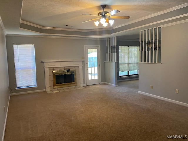 1853 Sanford Dr, Prattville, AL 36066 - unfurnished living room with a fireplace, crown molding, ceiling fan, carpet flooring, and a tray ceiling