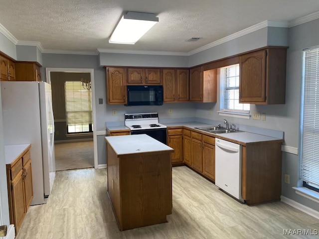 1853 Sanford Dr, Prattville, AL 36066 - kitchen featuring white appliances, light wood-type flooring, a center island, a textured ceiling, and light countertops