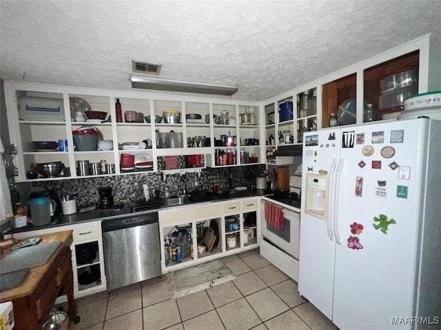 3740 Martha Ln, Millbrook, AL 36054 - kitchen with white appliances, light tile patterned flooring, open shelves, dark countertops, and a textured ceiling