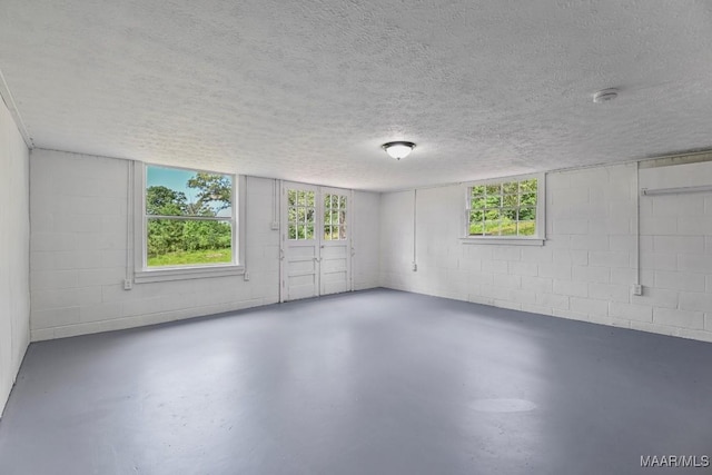 1582 W Old Hayneville Rd, Le Grand, AL 36105 - empty room with finished concrete floors, a textured ceiling, concrete block wall, plenty of natural light, and a smoke detector