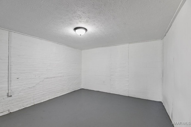 1582 W Old Hayneville Rd, Le Grand, AL 36105 - unfurnished room featuring concrete flooring, concrete block wall, and a textured ceiling