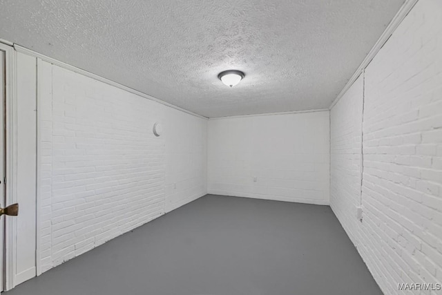 1582 W Old Hayneville Rd, Le Grand, AL 36105 - unfurnished room with concrete flooring, brick wall, and a textured ceiling