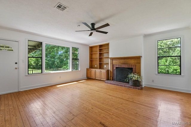 1582 W Old Hayneville Rd, Le Grand, AL 36105 - unfurnished living room featuring a ceiling fan, light wood-style flooring, a fireplace, baseboards, and crown molding