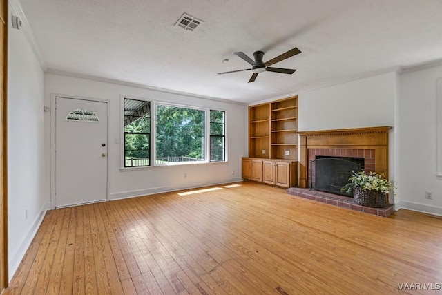 1582 W Old Hayneville Rd, Le Grand, AL 36105 - unfurnished living room featuring ornamental molding, a ceiling fan, light wood-style flooring, a brick fireplace, and built in features