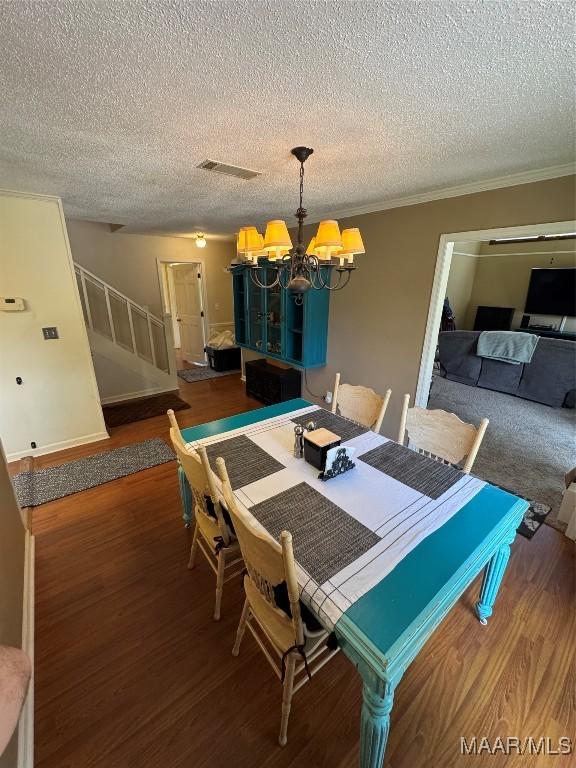215 W Castlewood Dr, Selma, AL 36701 - dining space with a chandelier, stairway, wood finished floors, a textured ceiling, and ornamental molding