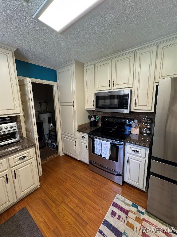 215 W Castlewood Dr, Selma, AL 36701 - kitchen featuring stainless steel appliances, light wood finished floors, a textured ceiling, and white cabinets