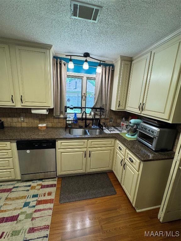 215 W Castlewood Dr, Selma, AL 36701 - kitchen with dishwasher, a sink, dark countertops, wood finished floors, and a textured ceiling