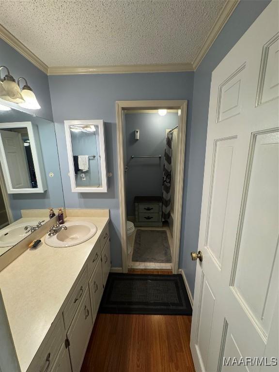 215 W Castlewood Dr, Selma, AL 36701 - bathroom with a textured ceiling, crown molding, wood finished floors, vanity, and toilet