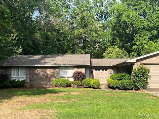 11 Wilkins Rd, Selma, AL 36701 - view of front facade featuring an attached garage, a front yard, brick siding, and roof with shingles