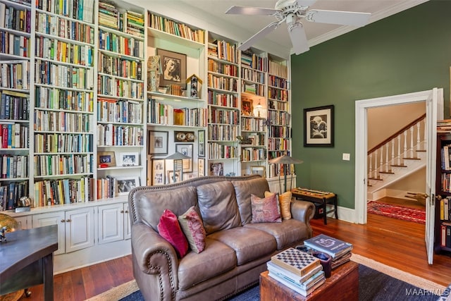 1533 Gilmer Ave, Montgomery, AL 36104 - living area featuring crown molding, wall of books, a ceiling fan, wood finished floors, and stairway