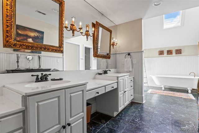 1533 Gilmer Ave, Montgomery, AL 36104 - full bathroom featuring double vanity, a wainscoted wall, a freestanding tub, and marble look tile flooring
