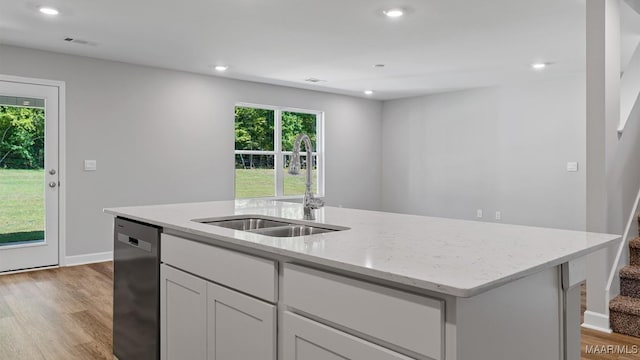 6008 Cunningham Trl, Montgomery, AL 36116 - kitchen featuring a sink, dishwasher, light stone counters, light wood finished floors, and a center island with sink