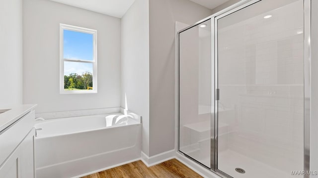 6008 Cunningham Trl, Montgomery, AL 36116 - bathroom with a stall shower, vanity, wood finished floors, baseboards, and a bath