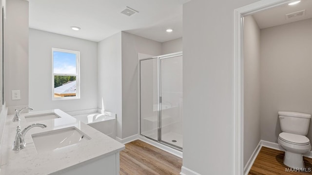 6008 Cunningham Trl, Montgomery, AL 36116 - full bath featuring toilet, a stall shower, double vanity, wood finished floors, and baseboards