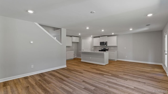 6008 Cunningham Trl, Montgomery, AL 36116 - unfurnished living room with baseboards, recessed lighting, light wood-style floors, and a sink