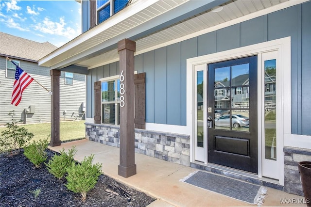 688 Tiger Trl, Opelika, AL 36804 - doorway to property featuring board and batten siding, covered porch, and stone siding