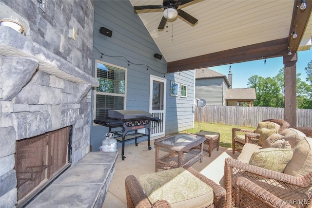 688 Tiger Trl, Opelika, AL 36804 - fenced backyard featuring area for grilling, a ceiling fan, a patio area, and an outdoor living space with a fireplace