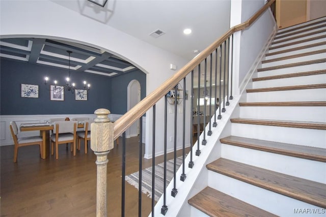 688 Tiger Trl, Opelika, AL 36804 - stairway featuring arched walkways, coffered ceiling, wood finished floors, a chandelier, and beamed ceiling