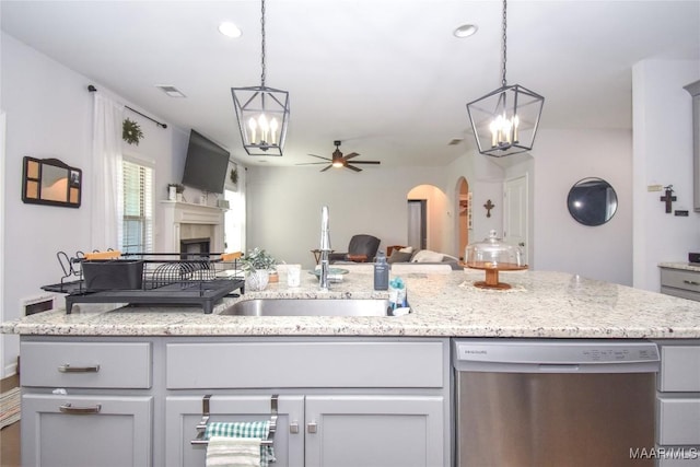688 Tiger Trl, Opelika, AL 36804 - kitchen with stainless steel dishwasher, a chandelier, a sink, open floor plan, and a fireplace