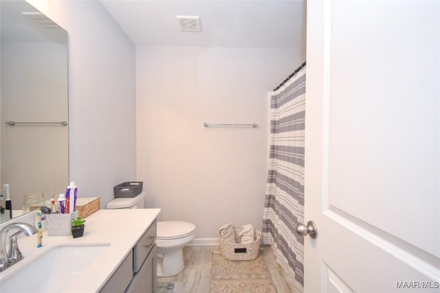 688 Tiger Trl, Opelika, AL 36804 - bathroom with toilet, vanity, baseboards, and curtained shower
