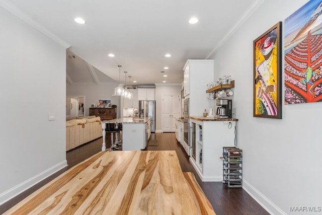 1478 Trolley Rd, Prattville, AL 36066 - kitchen with stainless steel appliances, white cabinetry, dark wood-type flooring, a kitchen bar, and a center island with sink