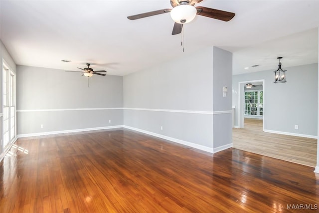 3212 Mcgehee Rd, Montgomery, AL 36111 - empty room with ceiling fan, a chandelier, wood finished floors, and baseboards